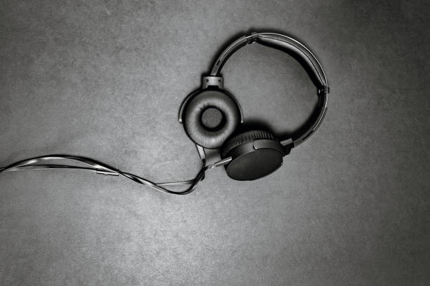 istock Black headphones on black matte background. Minimalistic composition top view. 1259038394