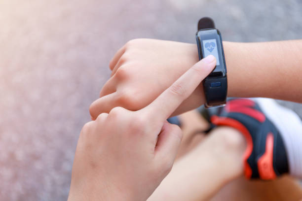 istock Close up Girl using smartwatch touching button and touchscreen on active sports. Finger touch button on smarth watch. Girl set smart watch before running on road. 1259049096