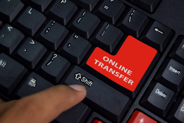 istock Online Transfer isolated on laptop keyboard background. 1259063264