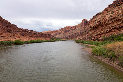 This is a view of the Colorado River running at historically low levels.  This shot was taken from the bridge crossing in Moab Utah and shows the spectacular red cliffs on both sides of the riverbank.