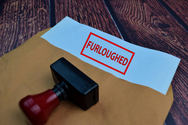 istock Red Handle Rubber Stamper and Furloughed text Isolated on wooden table background 1259065993