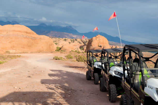 line of off road side by side vehicles on rock ledge in hell's revenge area near moab utah - off road vehicle quadbike desert dirt road photos et images de collection