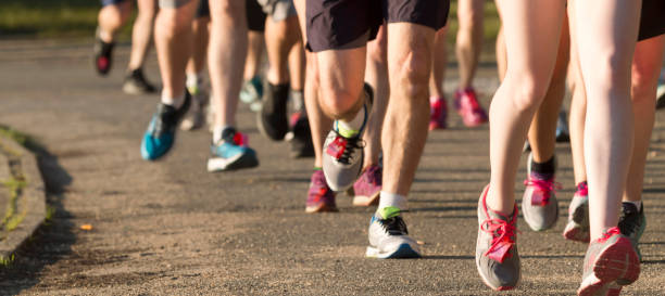 ขาของนักวิ่งบนเส้นทางสกปรกถัดจากทะเลสาบ - cross country running ภาพสต็อก ภาพถ่ายและรูปภาพปลอดค่าลิขสิทธิ์