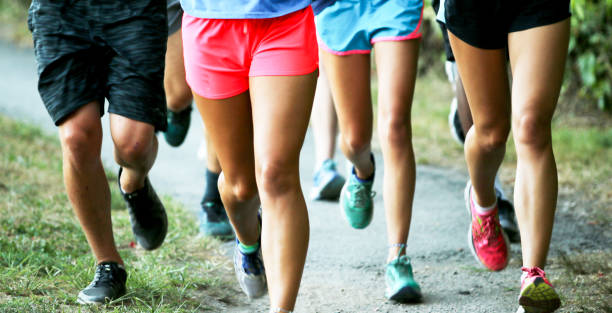 istock Front view of agGroup of runners training on a path together 1259070317