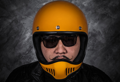 close up of biker man in motorcycle helmet and black leather jacket