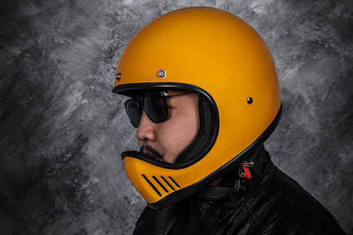 close up of biker man in motorcycle helmet and black leather jacket