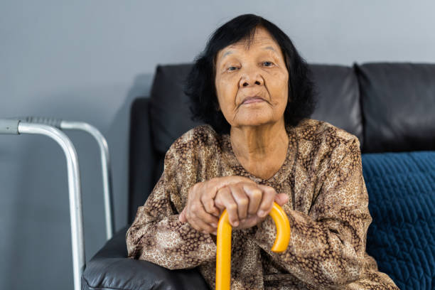 istock Senior woman with cane resting and sitting on couch 1259072301