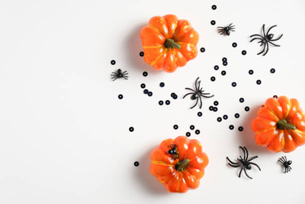 istock Halloween concept. Minimal style flat lay composition with pumpkins, spiders, confetti, decorations on white background. Halloween party invitation card mockup. Top view with copy space. 1259108010