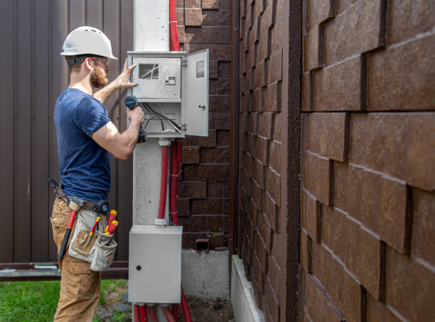 istock Electrician Builder at work, examines the cable connection in the electrical line in the fuselage of an industrial switchboard. Professional in overalls with an electrician's tool. 1259110607