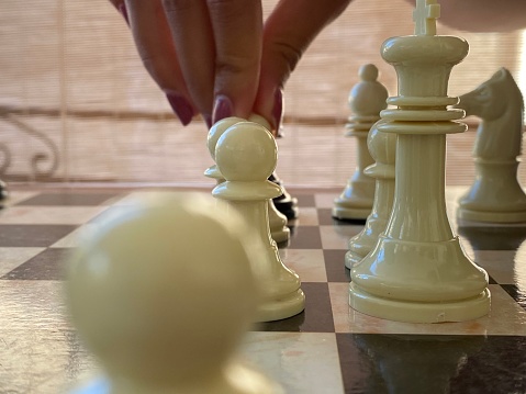 Close up of hand moving a chess piece