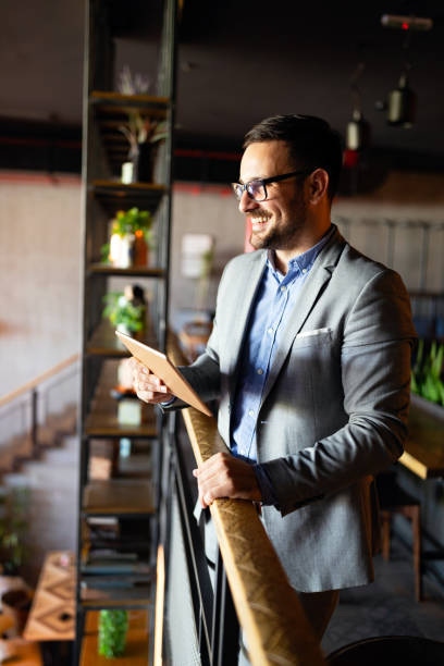 istock Happy young business man with tablet at work in modern office. 1259124528