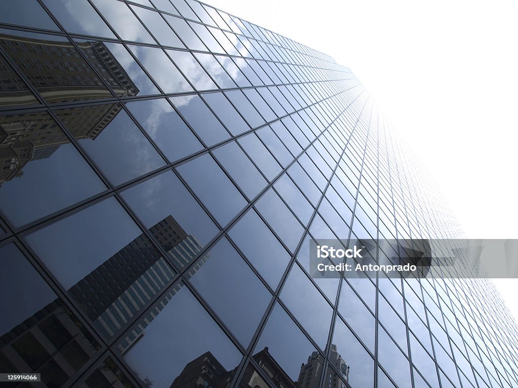 Glass window panels of a New York skyscraper High modern skyscrapers on a background of a bright sky and clouds. Apartment Stock Photo