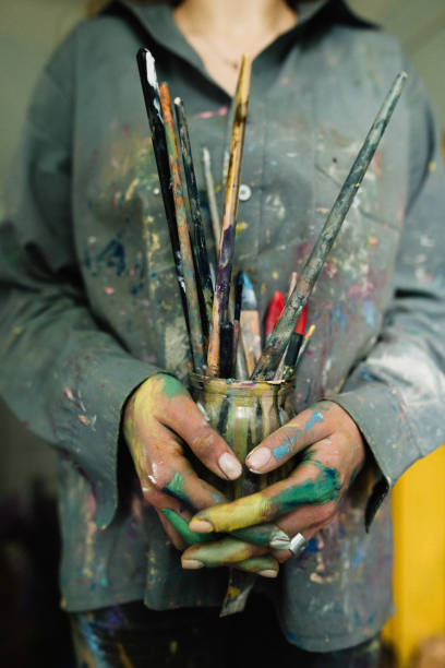 istock Woman holding brushes in her hands in home art studio 1259149001