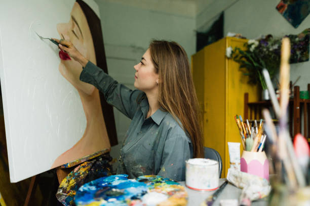 istock Beautiful woman painter drawing in home art studio 1259149554