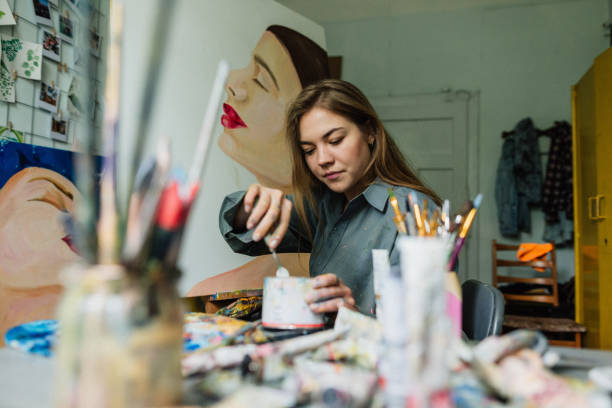 istock Beautiful woman painter drawing in home art studio 1259149566