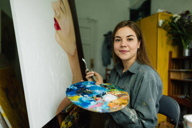 istock Beautiful woman painter drawing in home art studio 1259149640