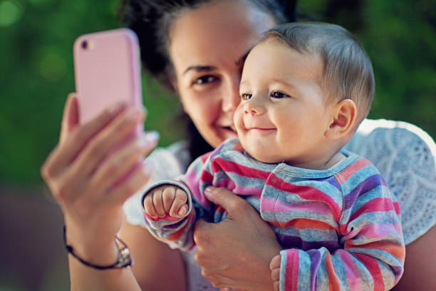 istock Mother is hugging her baby and taking selfie/making video call 1259149648