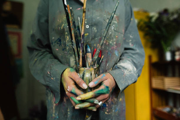 istock Woman holding brushes in her hands in home art studio 1259149660