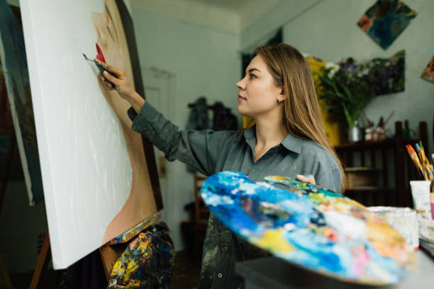 istock Beautiful woman painter drawing in home art studio 1259149666