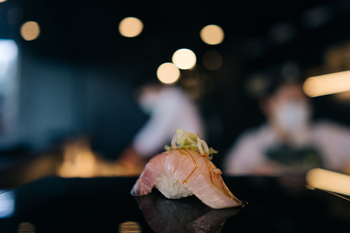 Omakase style dining in a sushi restaurant where the chef pre-determines the menu for you in a multi-course meal.
