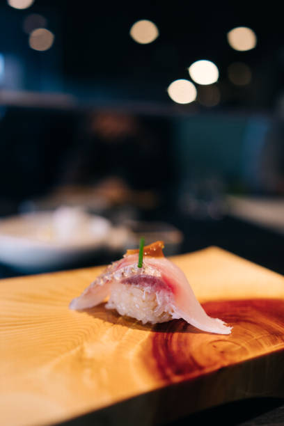 Omakase style dining in a sushi restaurant where the chef pre-determines the menu for you in a multi-course meal.
