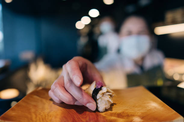 Omakase style dining in a sushi restaurant where the chef pre-determines the menu for you in a multi-course meal.