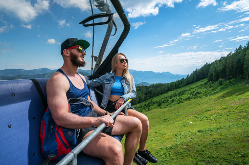 Young woman and a man on a ski lift in Hinterstoder ski and hiking resort