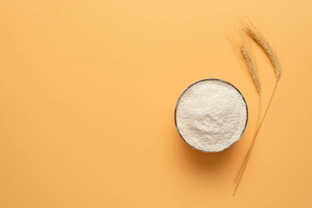 farina integrale in una ciotola isolata su sfondo beige. ciotola di farina vista dall'alto - whole wheat flour foto e immagini stock