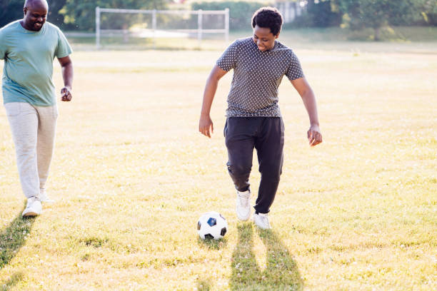istock Playing soccer with teen son 1259160150
