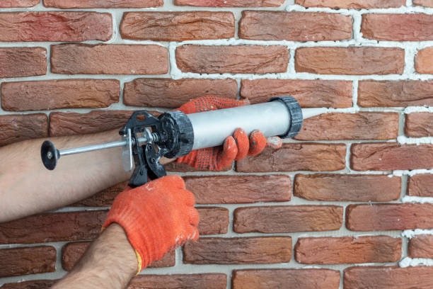 istock Grouting decorative gypsum brick with white cement grout. Applying grout with syringe. 1259161016