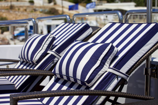 Blue and white striped loungers on deck of yacht. Focus in the front. Stock image.