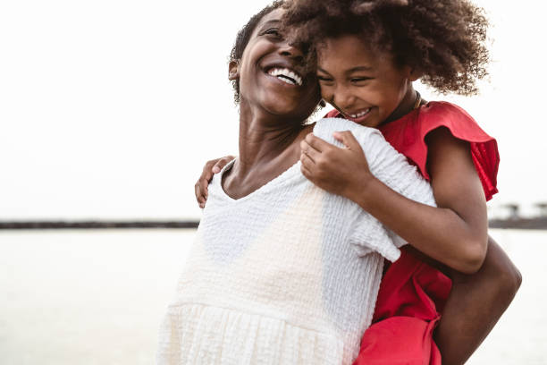 glückliche afrikanische familie am strand während der sommerferien - afro-amerikaner mit spaß in der urlaubszeit - eltern lieben und reisen lifestyle-konzept - women mature adult black american culture stock-fotos und bilder