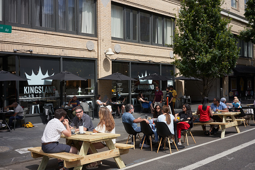 Portland, OR, USA - July 11, 2020: On-street outdoor dining on a Saturday morning at a breakfast, brunch, and lunch joint in downtown Portland, Oregon, amid the coronavirus pandemic.