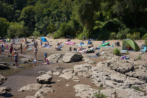 Lake Oswego, OR, USA - July 20, 2020: The Willamette River beach in a Lake Oswego city park is packed with visitors on a hot summer day amid the coronavirus pandemic.