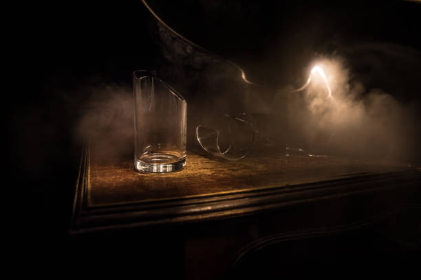 vidros quebrados na mesa de madeira em fundo escuro tonificado com neblina. foco seletivo - splintering - fotografias e filmes do acervo