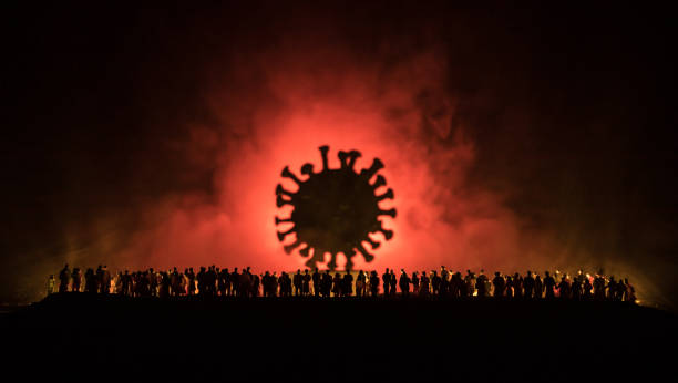 istock Coronavirus 2019-nCov novel coronavirus concept. Crowd looking on big Corona virus model at night with fog and backlight. Creative artwork decoration. Selective focus. 1259212811