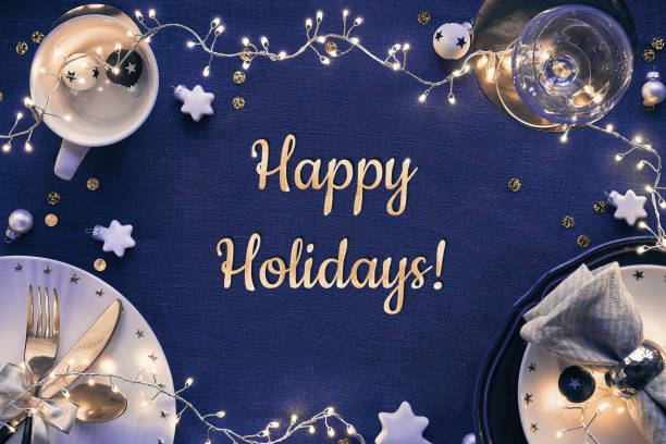 istock Text Happy Holidays. Christmas table setup with white and golden decor, blue linen tablecloth, flat lay 1259249808