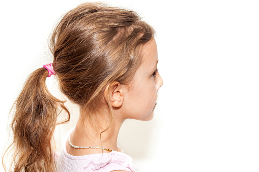 Five year old girl portraits with pink sleeveless dress against a white backdrop.