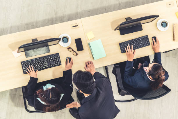 istock Business people wearing headset from top view in office working with computer 1259254534