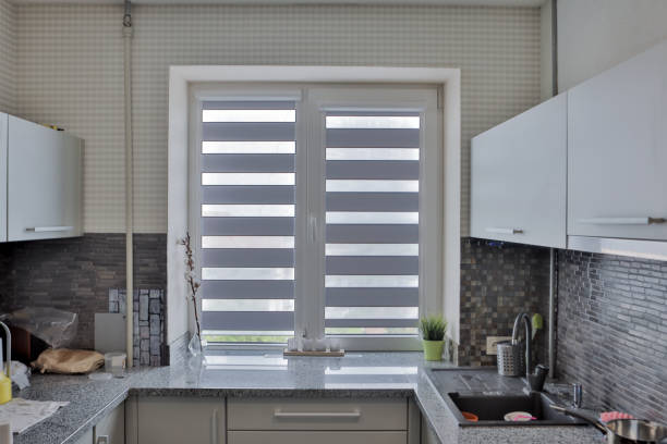 istock Modern gray kitchen features gray flat front cabinets paired with gray countertops and a glossy gray linear tile backsplash. 1259263549