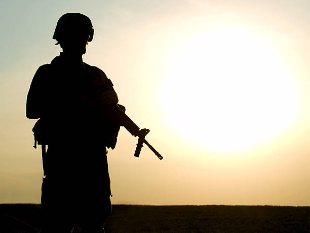 US soldier Silhouette of US soldier with rifle against a sunset libya stock pictures, royalty-free photos & images