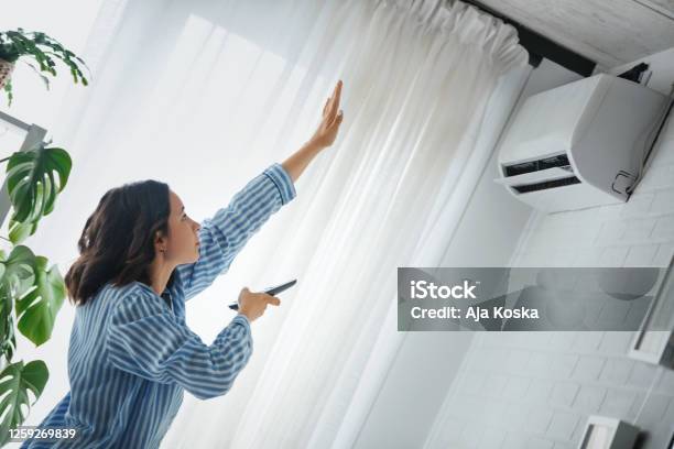 Turning On The Air Conditioner Stock Photo - Download Image Now - Air Conditioner, Heat - Temperature, Domestic Life