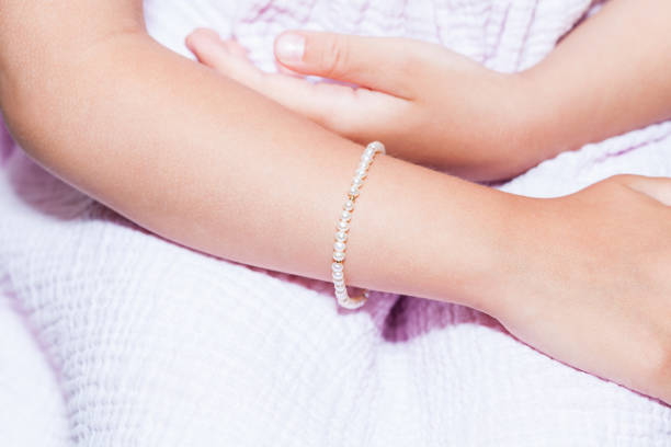 Pearl bracelet on young girl's arm close-up stock photo
