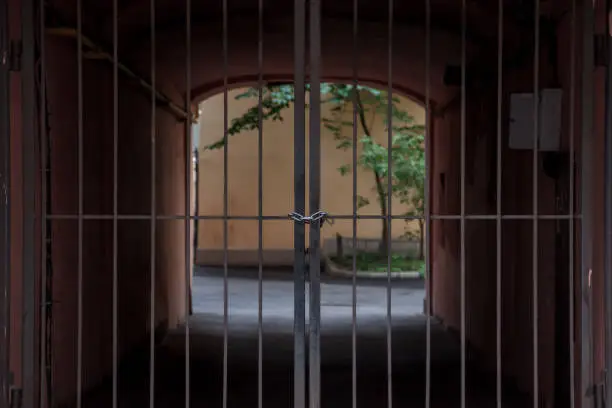 Photo of Beyond wrought-iron gates is an arch with light and greenery