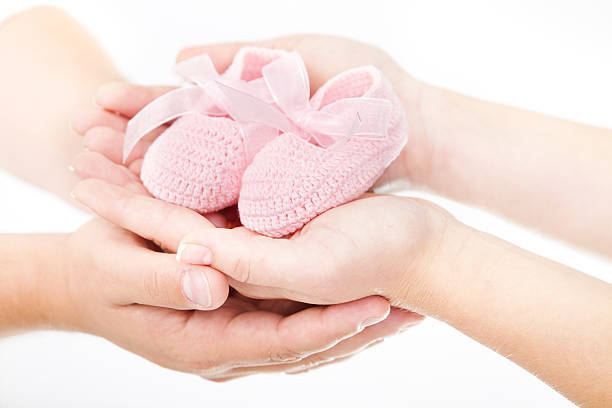 어머니 및 아버지의 손을 쥠 핑크 신생아 아기 신발 한 쌍을 보고 기뻐합니다 - baby booties studio shot horizontal shoe 뉴스 사진 이미지