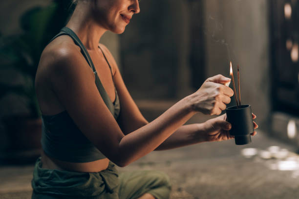 istock Yoga in the Garden: a Smiling Woman Lighting Incense Sticks to Support her Practice 1259290795