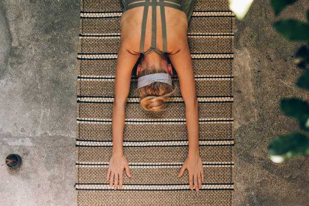 istock Woman Stretching her Body While Doing Yoga 1259290804