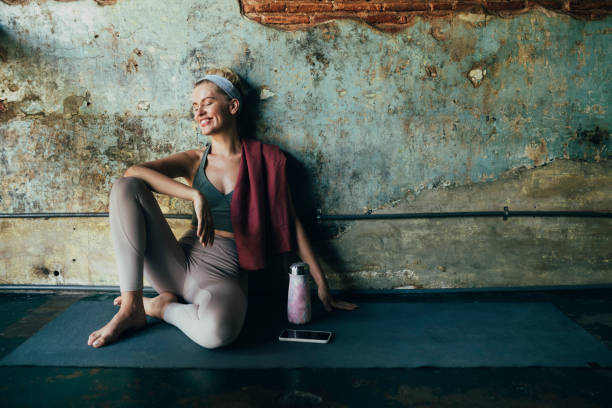 istock Happy Blonde Woman Using a Smartphone While Doing Yoga at Home 1259290873