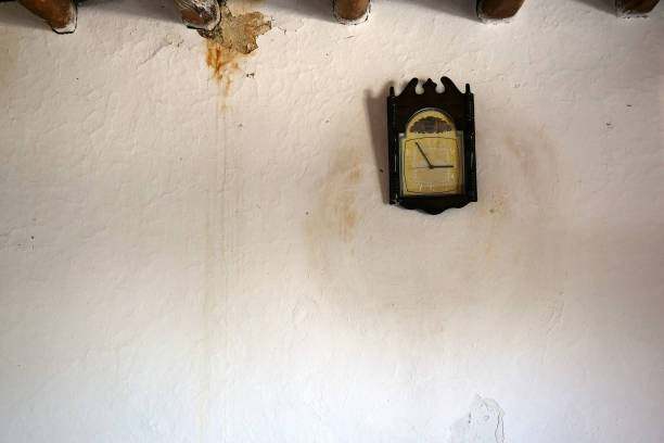 istock wall clock mounted on adobe wall, obsolete adobe wall,rapid flow of time, year and time, 1259296204