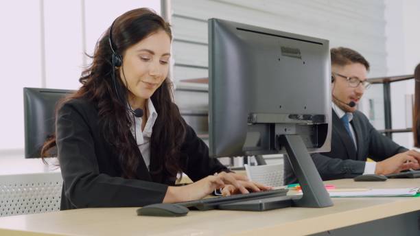 istock Business people wearing headset working in office 1259300820